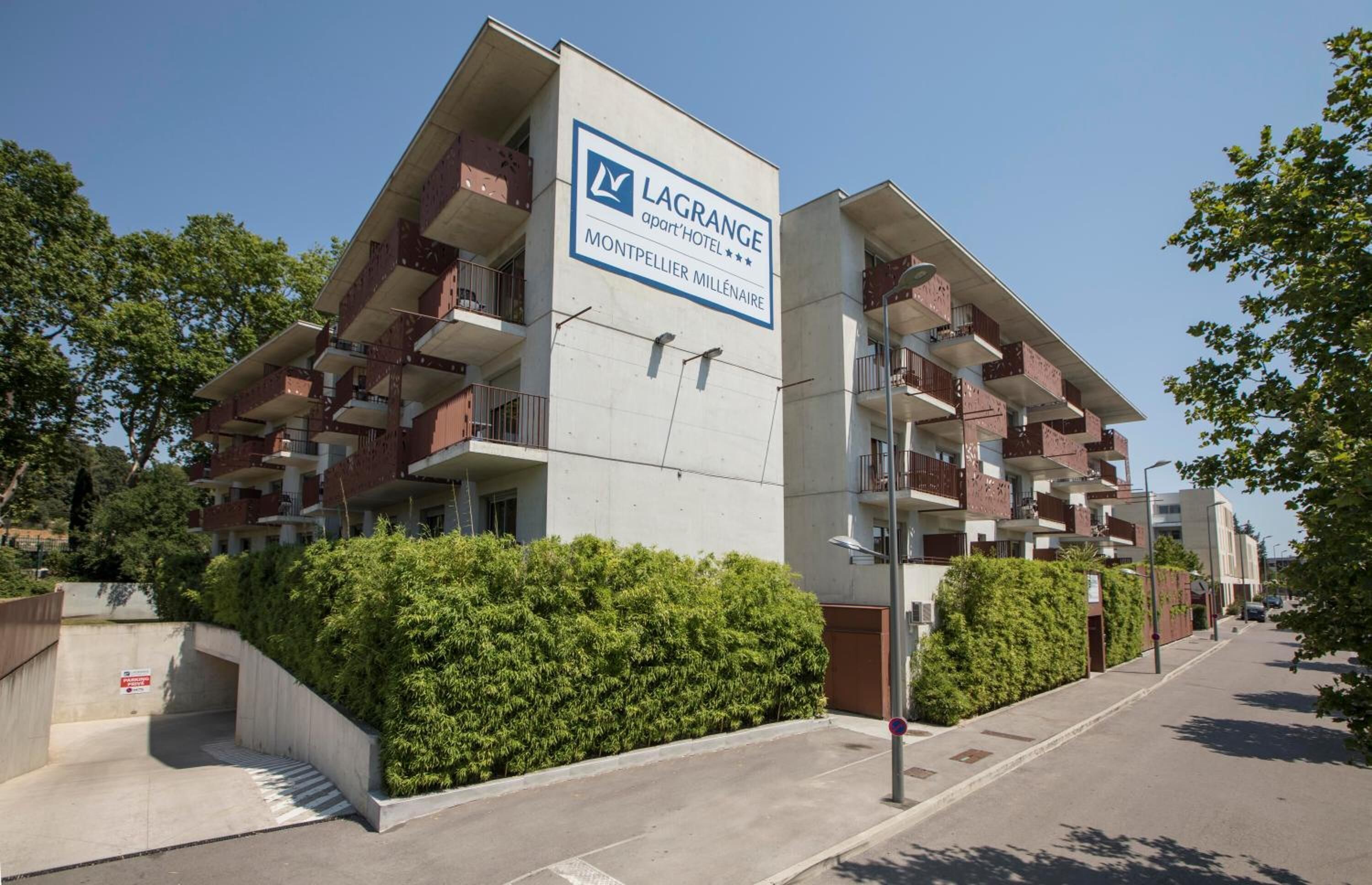 Un hotel moderno con un letrero destacado que dice LAGRANGE apart HOTEL.