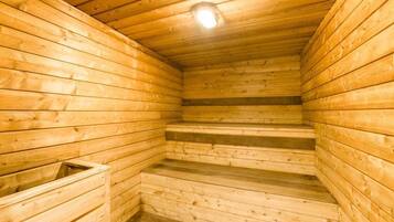 Una sauna de madera con techo inclinado y una lámpara.