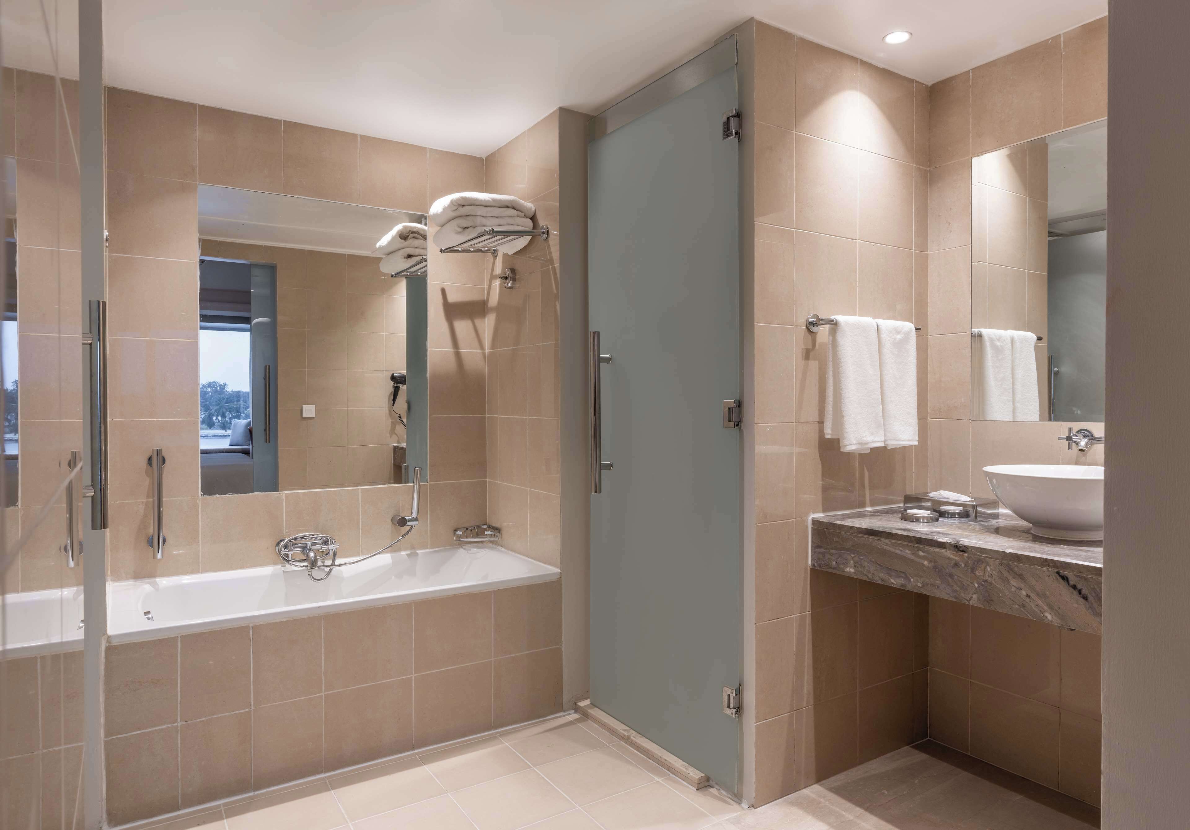 A modern bathroom with a bathtub, a glass-enclosed shower, and a vanity with a sink.