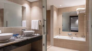 A modern bathroom with a glass-enclosed shower, a large sink, and a bathtub.