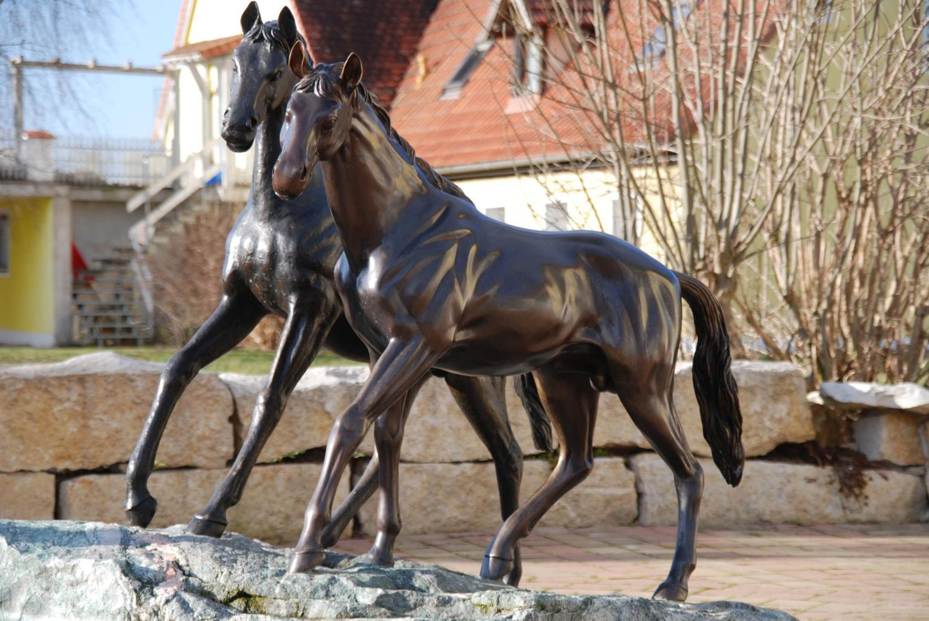 A bronze horse statue in an outdoor setting.