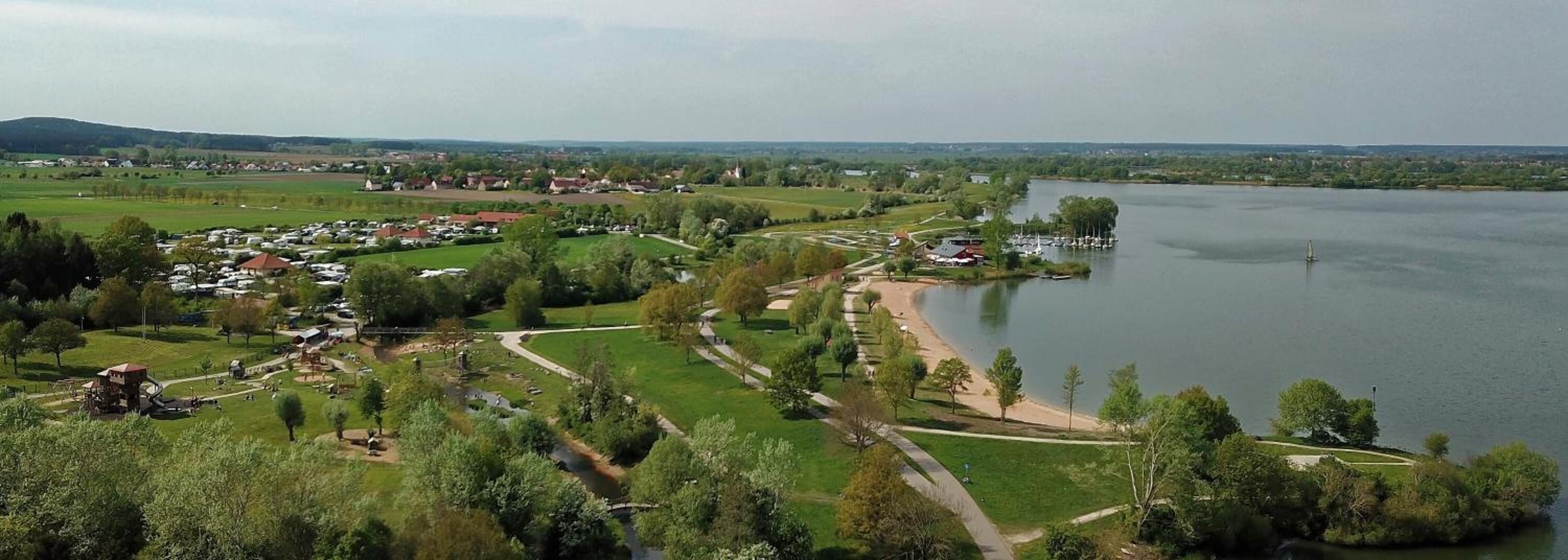 Une zone au bord du lac comprenant un parc, des sentiers pédestres et un port de plaisance.