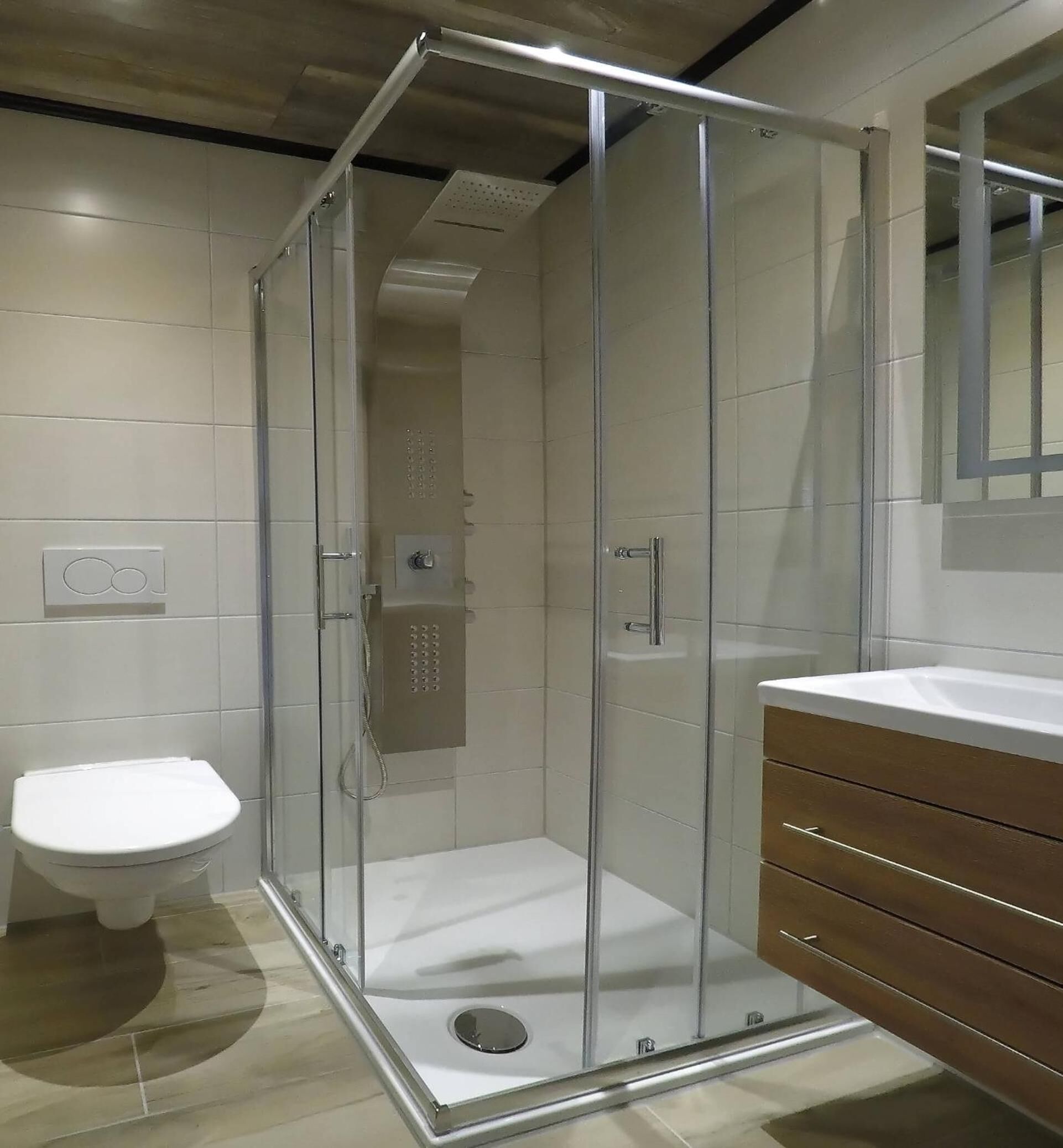 Ein modernes Badezimmer mit Duschkabine, Toilette und Waschtisch mit Spiegel.