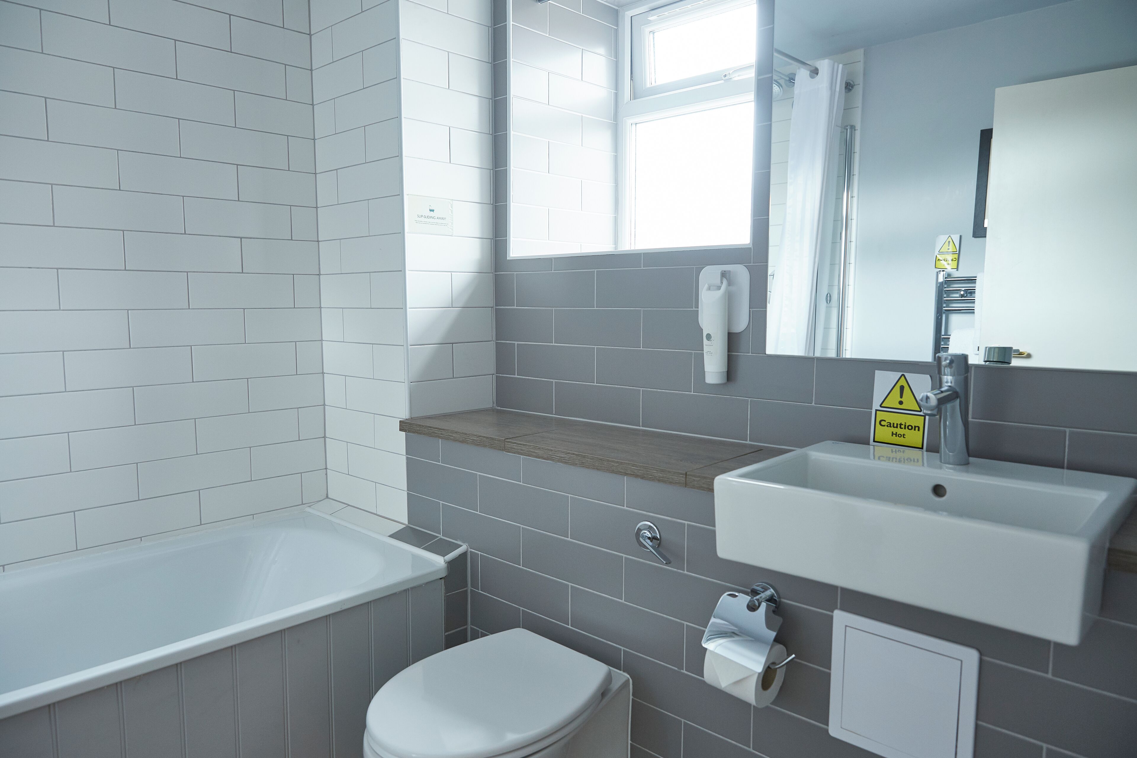 A modern bathroom with a bathtub, toilet, and sink.