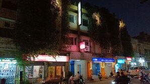 Una calle con varios comercios y un cartel de hotel a la vista.