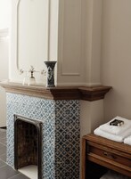 Un baño con pared de azulejos, un armario de madera y un perchero.