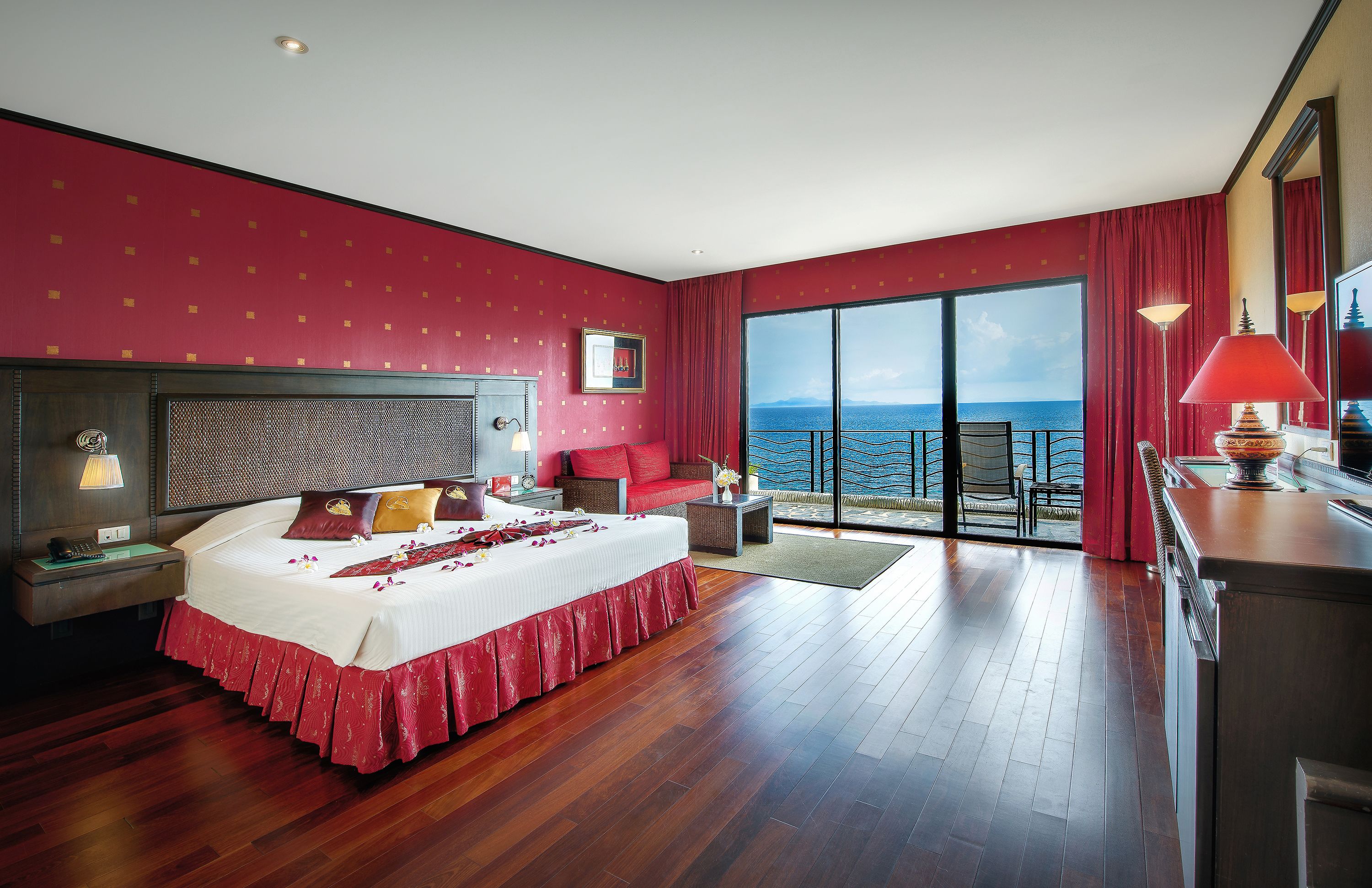 Un dormitorio amplio con una cama grande, un balcón con vistas al mar y un diseño moderno.