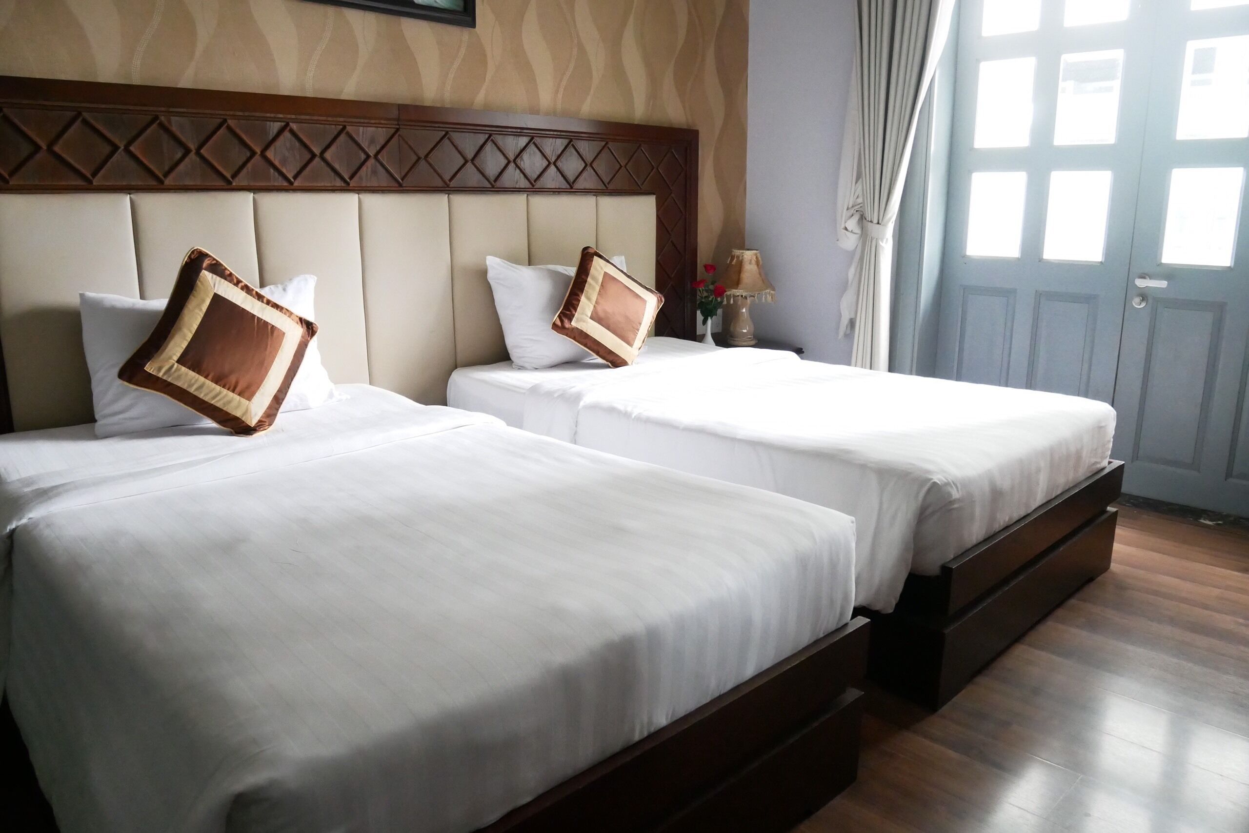Une chambre d’hôtel avec deux lits, chacun doté d’une tête de lit et d’un oreiller.