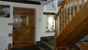 Un escalier en bois, doté d’une rampe, mène à un palier.