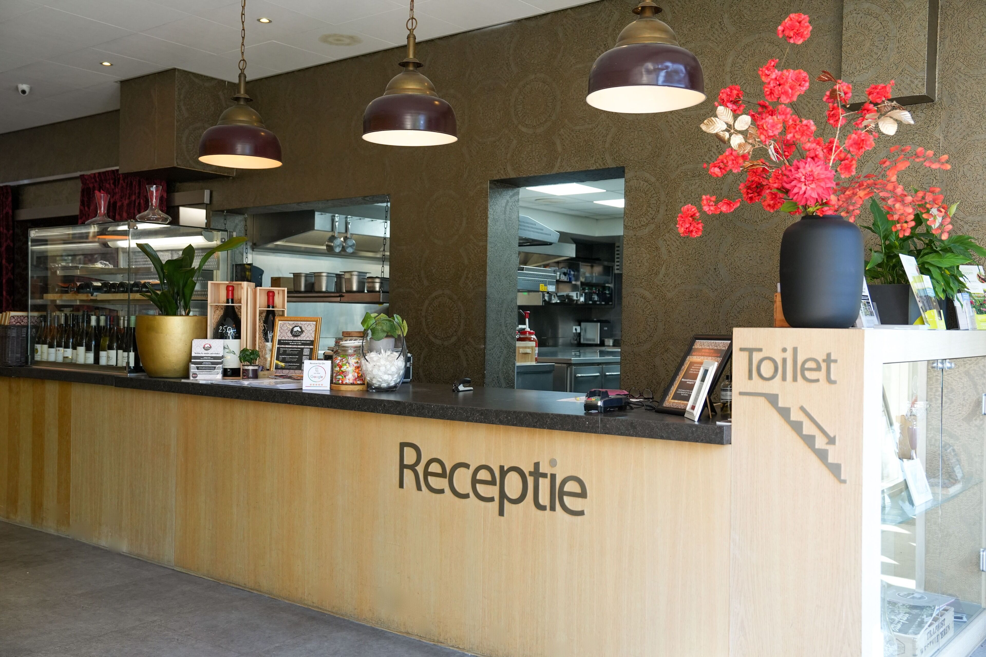 A reception area with a wooden counter, a mirror, and a sign indicating the location of the toilet.
