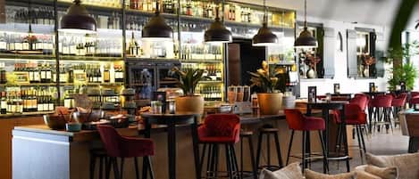A bar area with multiple stools, a bar counter, and shelves stocked with bottles.