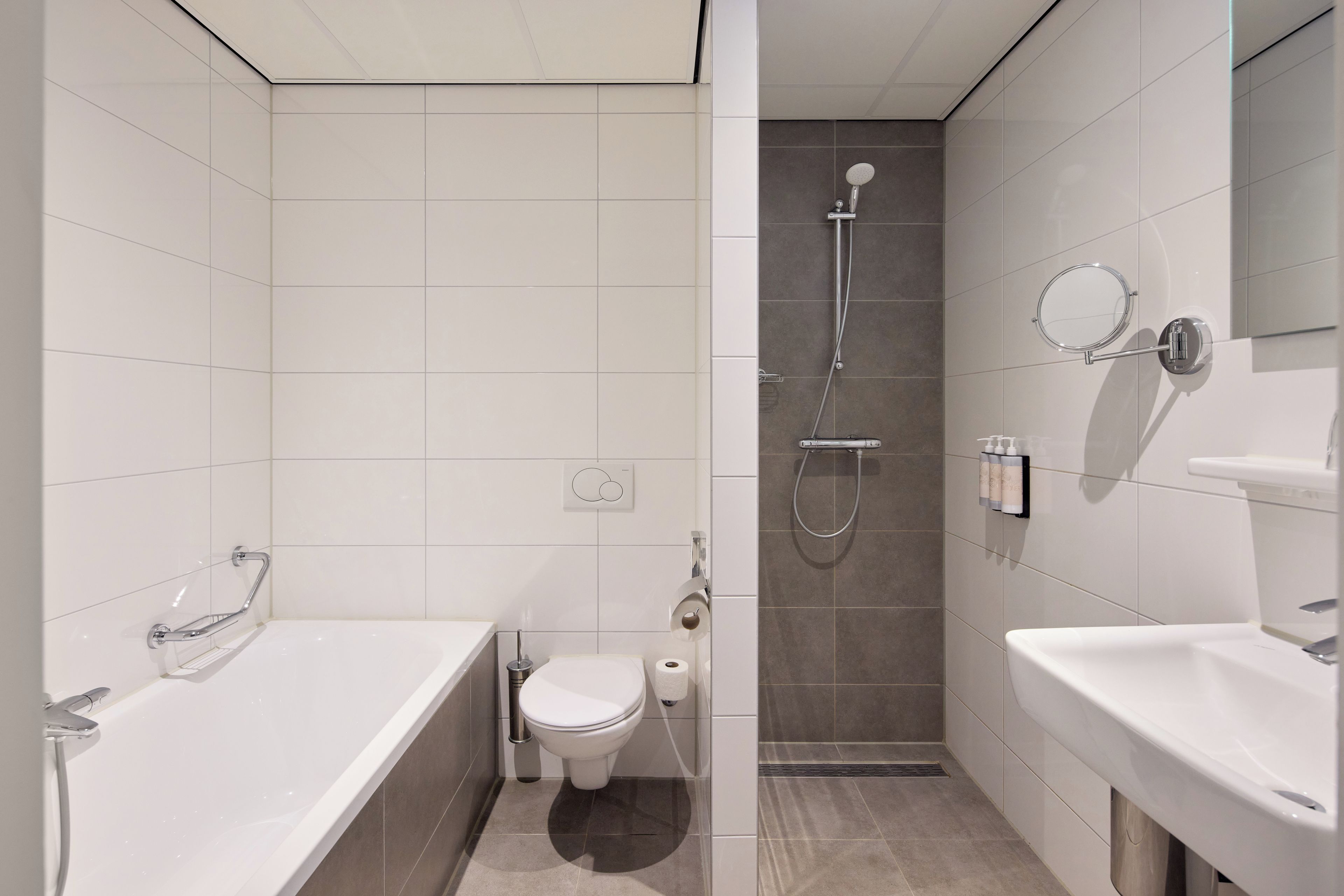A modern bathroom with a bathtub, toilet, and shower area.