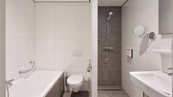 A modern bathroom with a bathtub, toilet, and shower area.