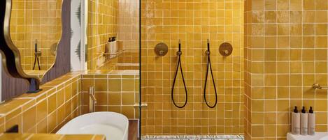 Un baño con bañera, ducha con cabezal de lluvia e inodoro de pared.