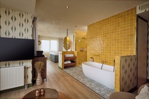 A modern living room with a flat-screen TV, a sofa, a coffee table, and a decorative vase.