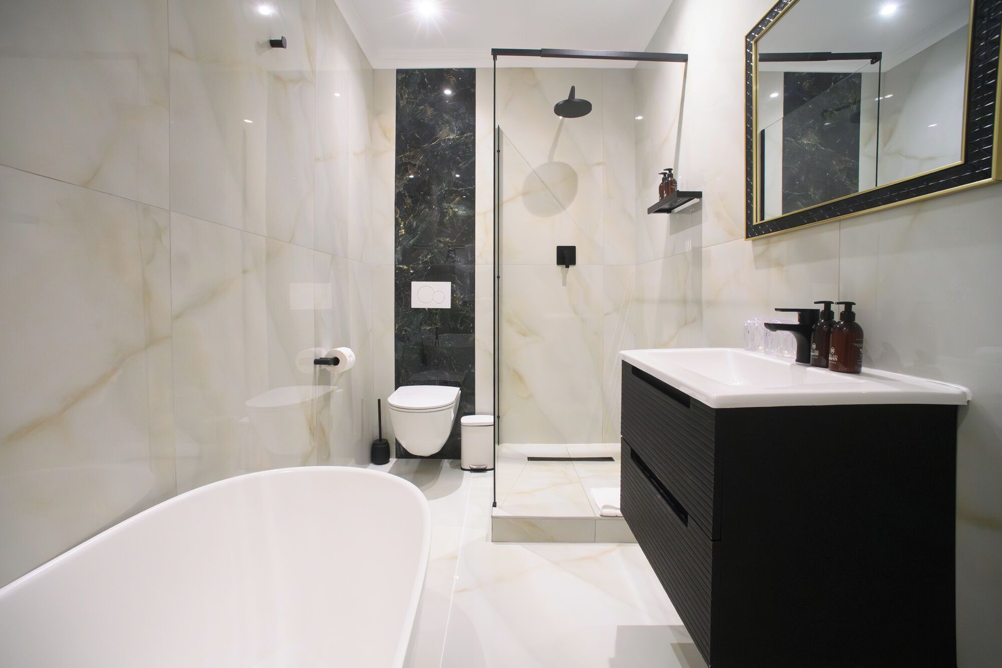 A modern bathroom with a bathtub, toilet, and shower area.