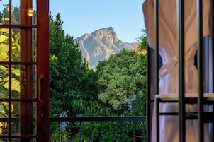 A mountain view through a window with a metal railing.