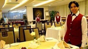 A restaurant with tables set for dining, waitstaff in red vests, and a modern interior design. - Sharjah Palace Hotel (Sharjah)