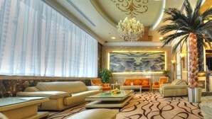 A spacious lobby with a large seating area, a chandelier, and a large abstract painting on the wall. - Sharjah Palace Hotel (Sharjah)