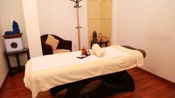 Relax in a spacious room with a large bed, a comfortable chair, and a convenient table.