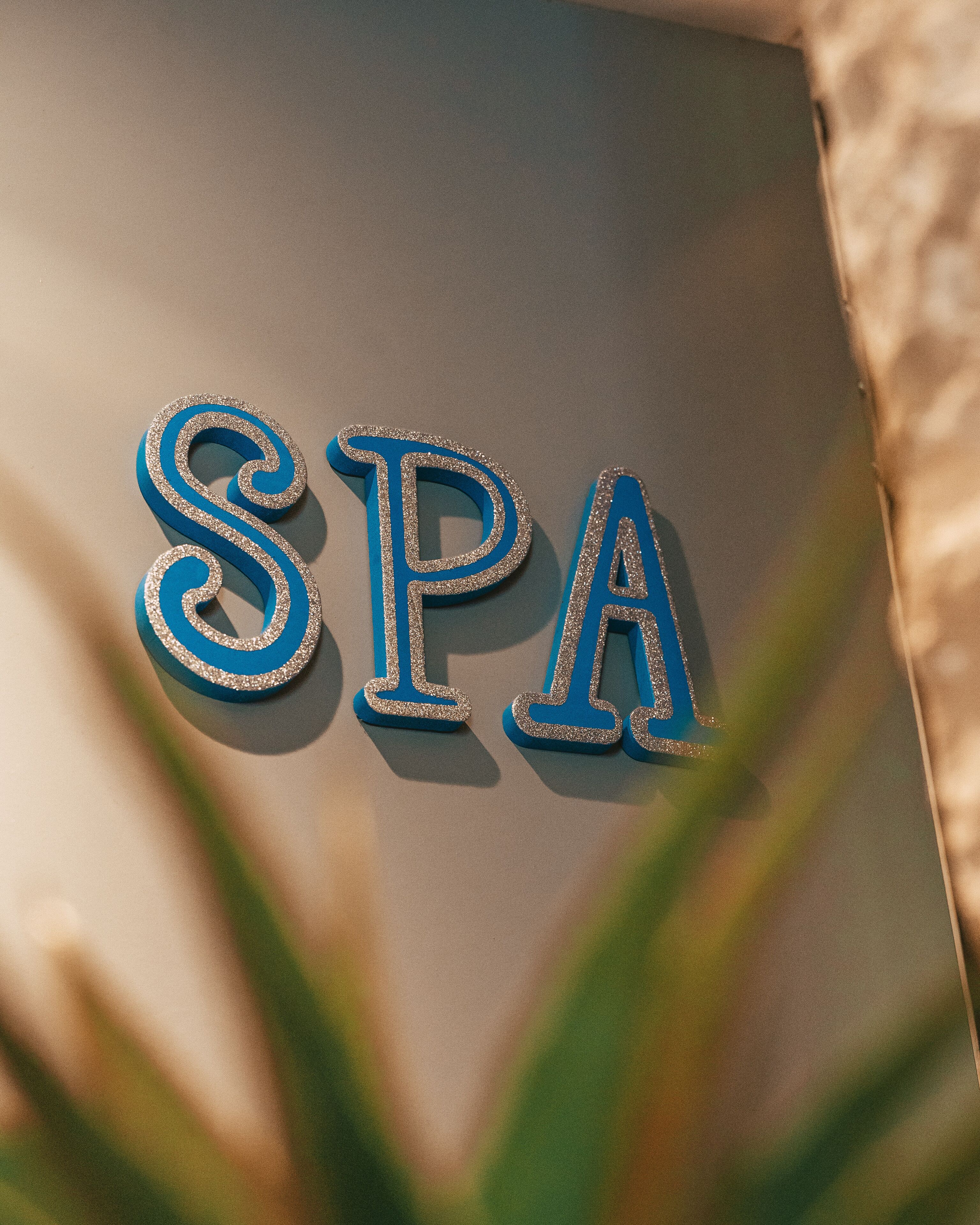 Un letrero con las letras 'SPA' en una tipografía decorativa, probablemente indicando un establecimiento de spa.