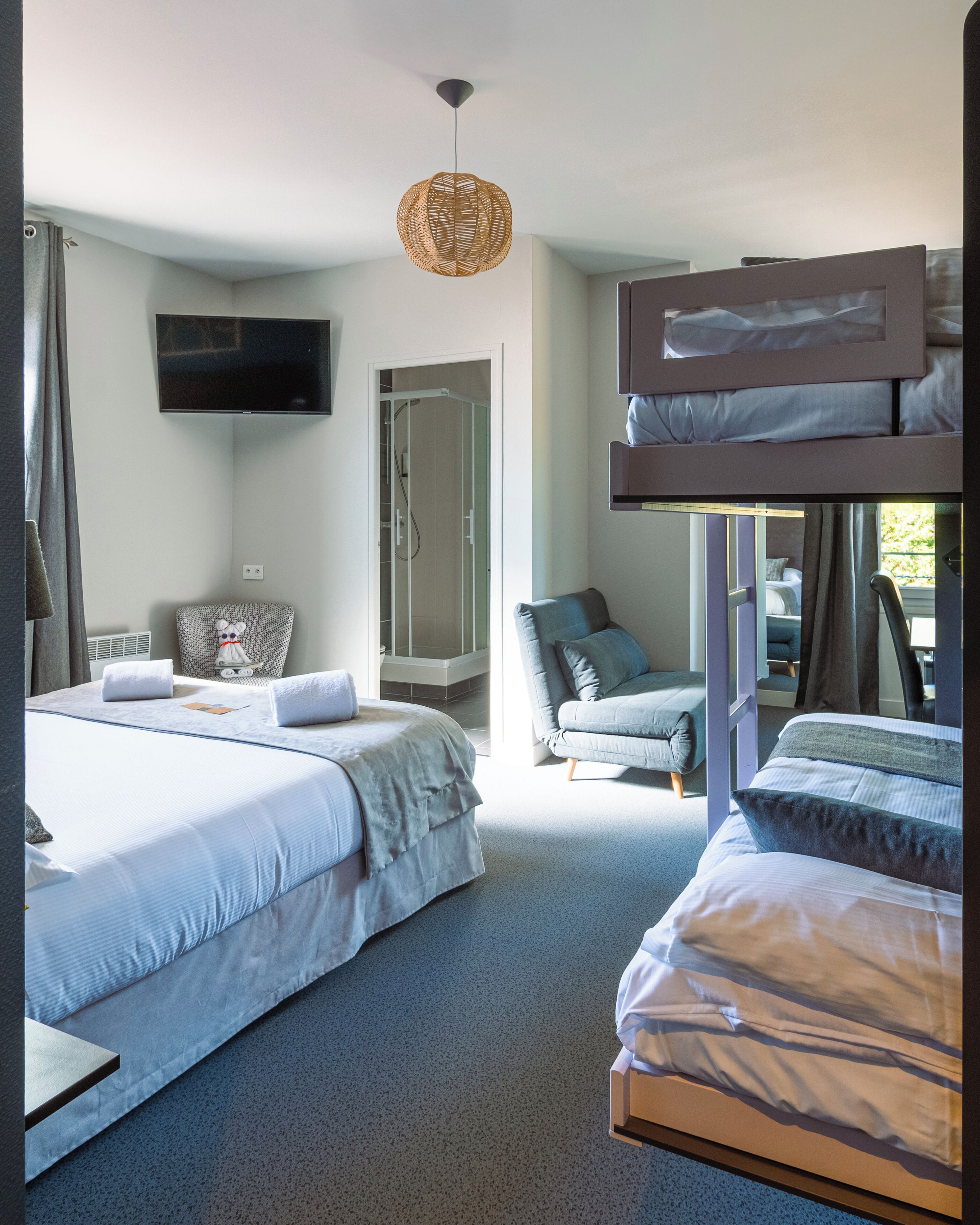 Une chambre d’hôtel moderne avec deux lits, une télévision, une douche et une vue sur l’extérieur.