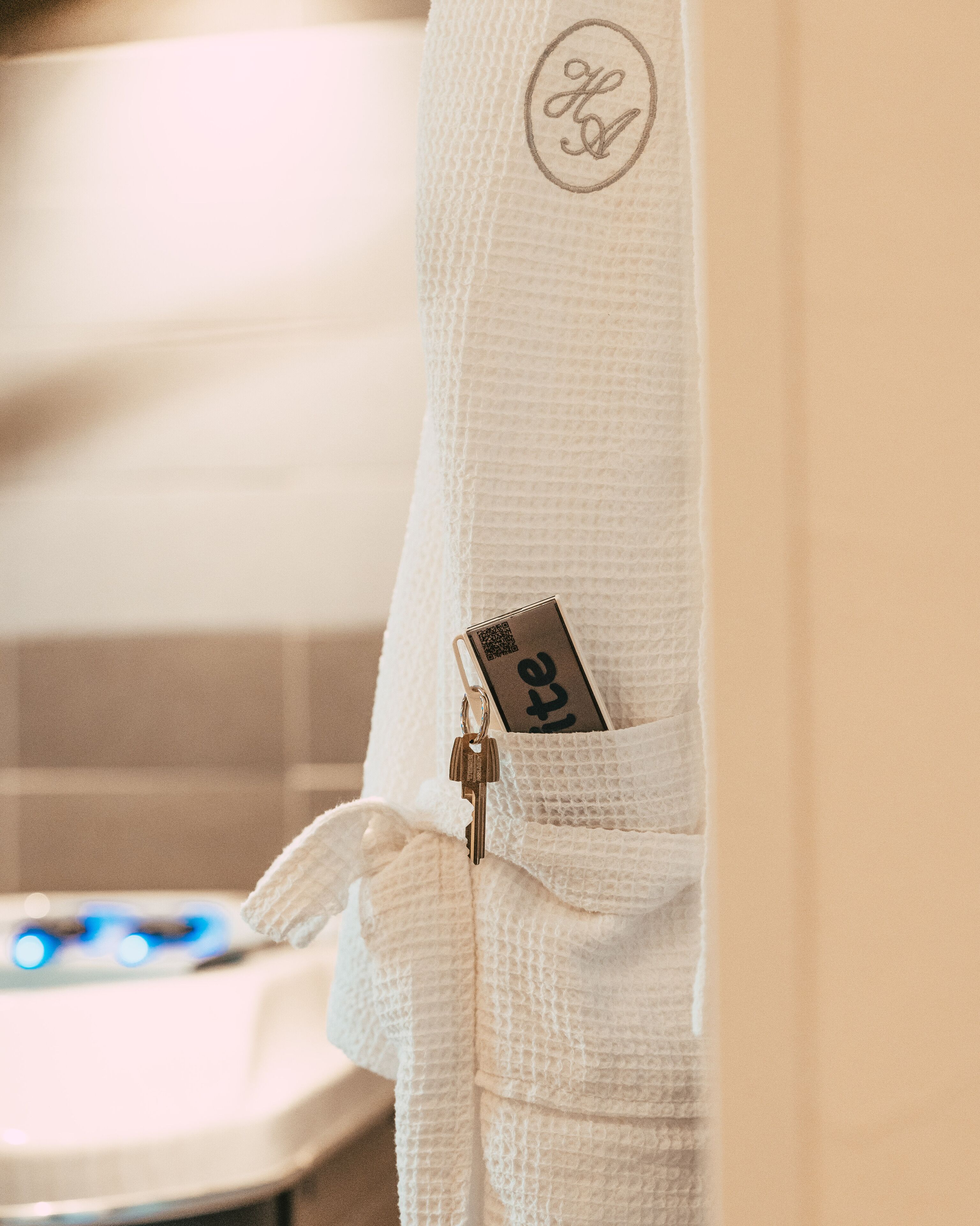 A white towel with a keychain and a tag hanging from it.