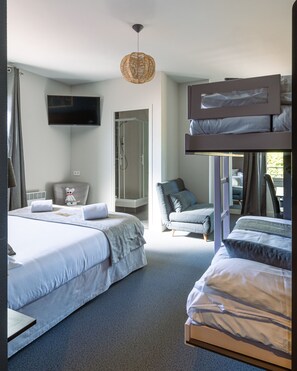 Une chambre d’hôtel moderne avec deux lits, une télévision, une douche et une vue sur l’extérieur.