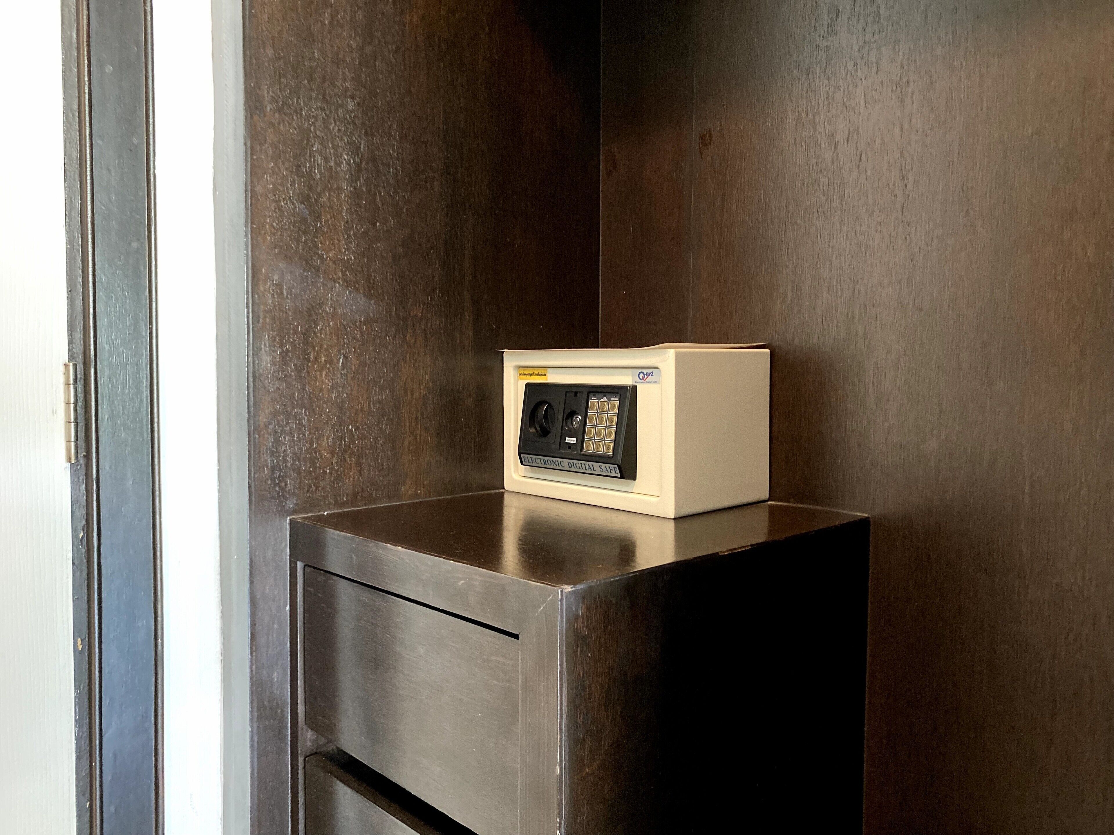 Un armario metálico con un pequeño dispositivo electrónico encima, posiblemente un sistema de seguridad, frente a una pared oscura.