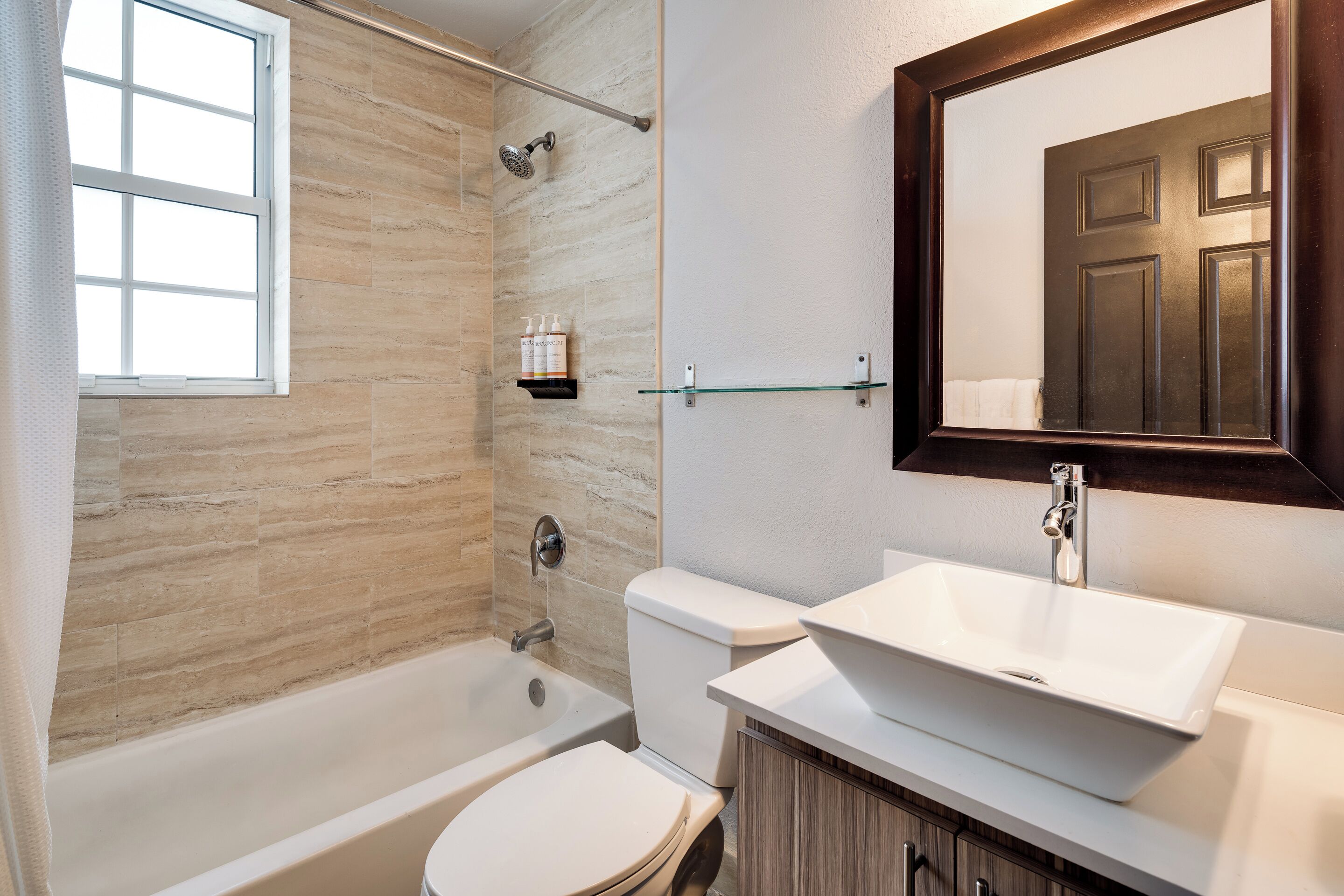 Un baño moderno con bañera, inodoro y lavamanos.