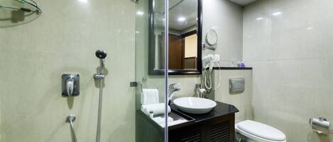 Ein modernes Badezimmer mit Duschkabine aus Glas, Waschbecken mit Spiegel und Toilette.