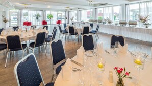 A spacious dining area with round tables set for a meal, surrounded by chairs. - Best Western Plus iO Hotel (Schwalbach am Taunus)