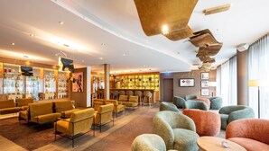 A modern lobby with seating areas, a bar, and a sports bar. - Best Western Plus iO Hotel (Schwalbach am Taunus)