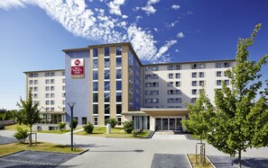 A multi-story hotel with a prominent Best Western Plus sign, a paved courtyard, and surrounding greenery. - Best Western Plus iO Hotel (Schwalbach am Taunus)
