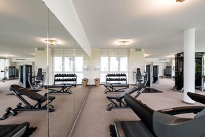 A gym with exercise equipment, mirrors, and windows. - Best Western Plus iO Hotel (Schwalbach am Taunus)