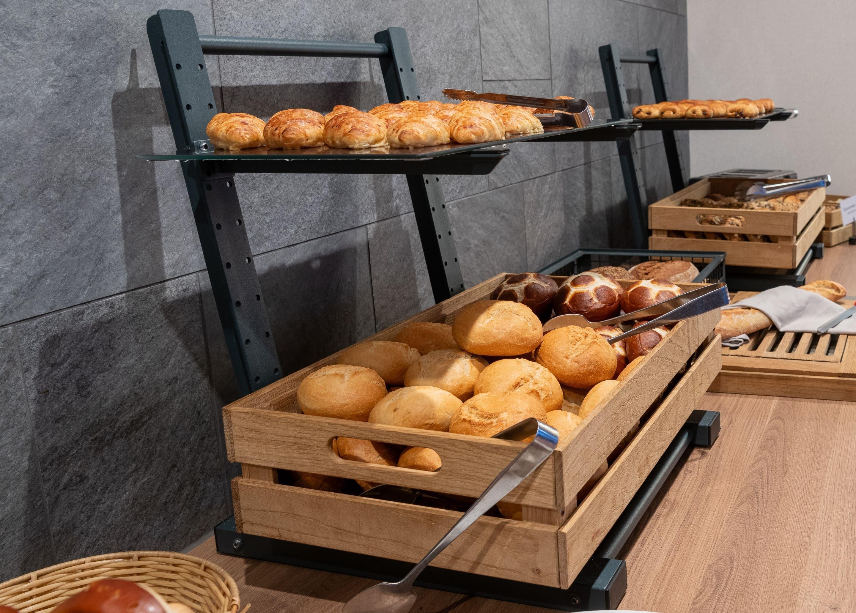 A bakery display with various baked goods in wooden crates and on metal racks.