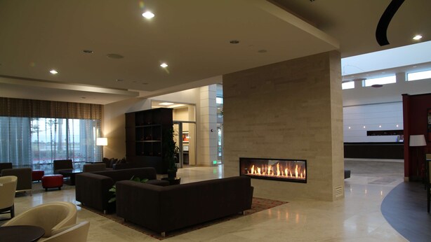 Eine großzügige Lobby mit Kamin, bequemen Sitzgelegenheiten und modernem Design.
