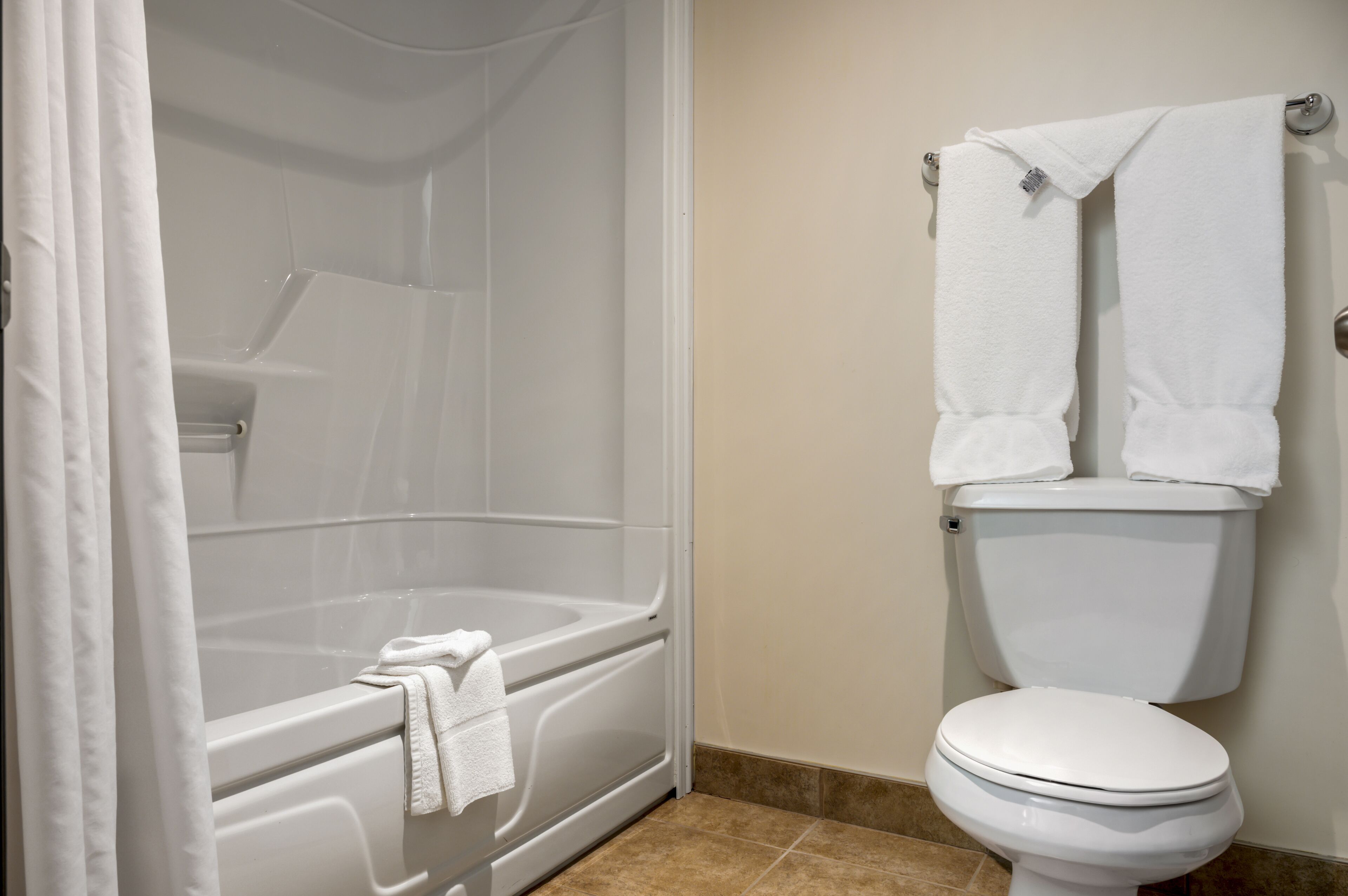 Ein Badezimmer mit Badewanne, Toilette und Duschvorhang.