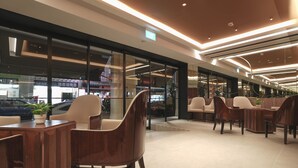 A modern interior with seating areas and a glass storefront. - Hotel 1900 @ Chinatown (Singapore)