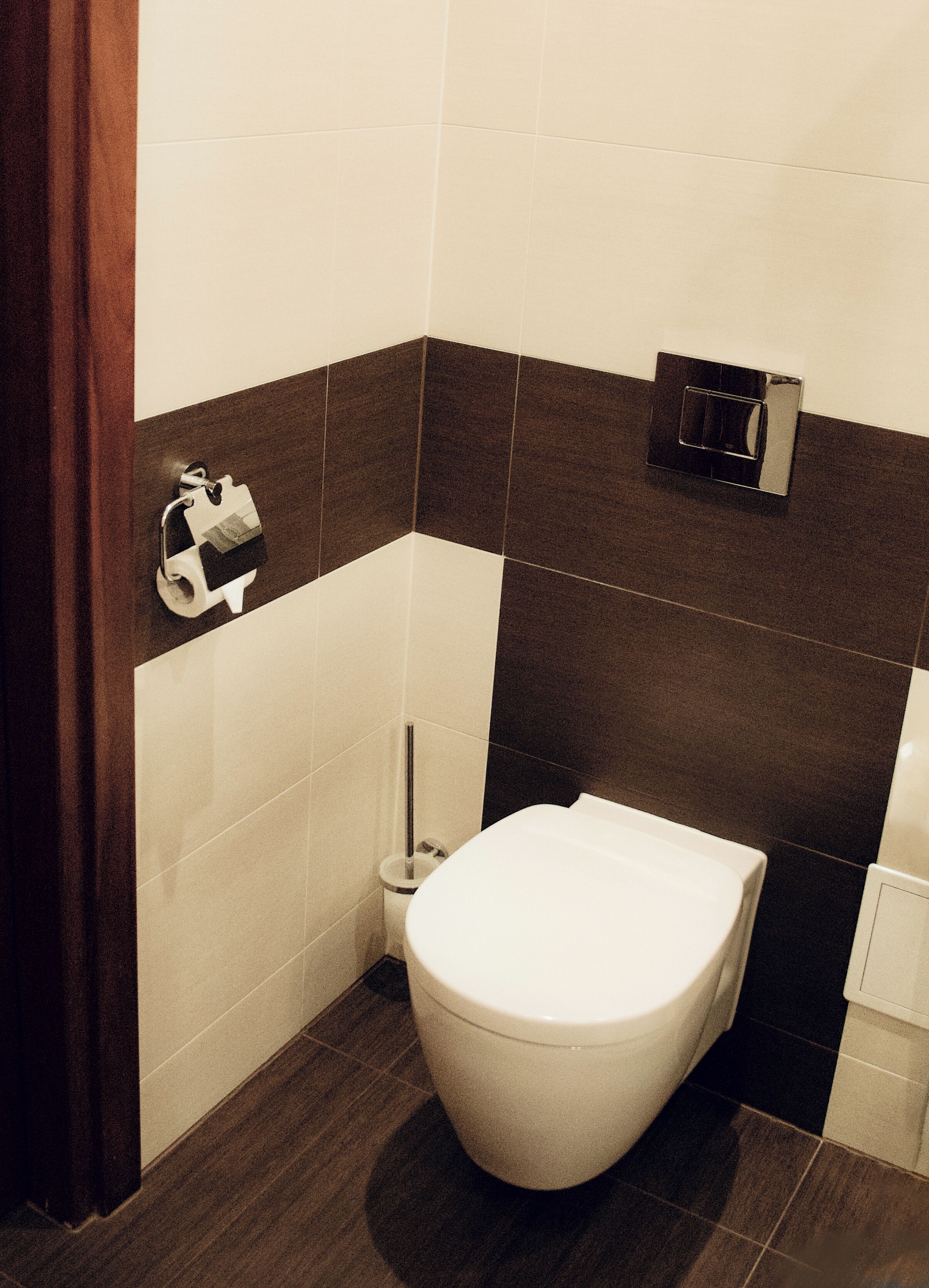 Un baño con inodoro, dispensador de papel higiénico y bidé.