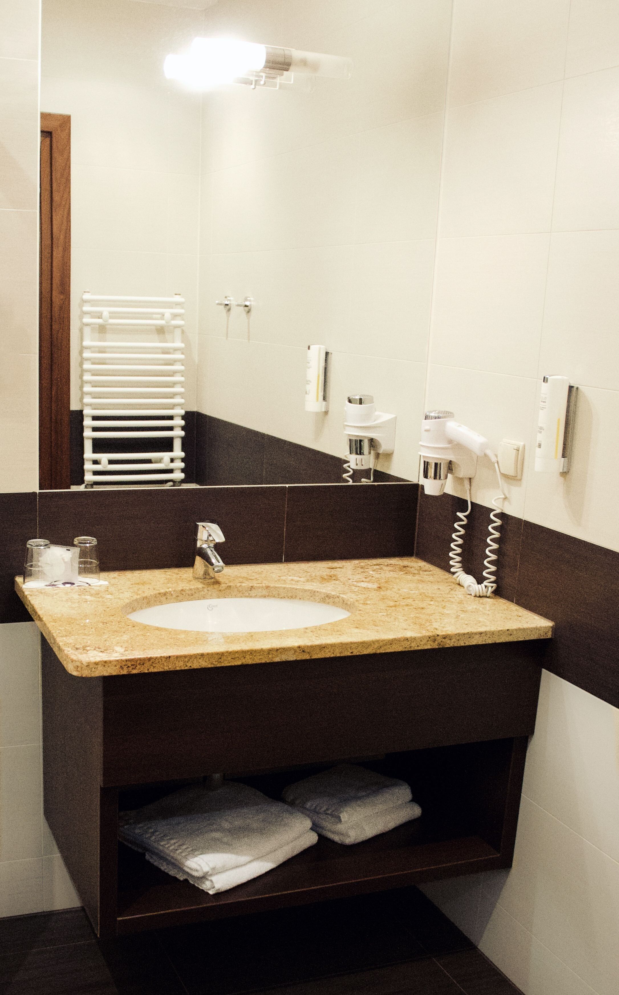Casa de banho com lavatório, toalheiro e secador de cabelo.