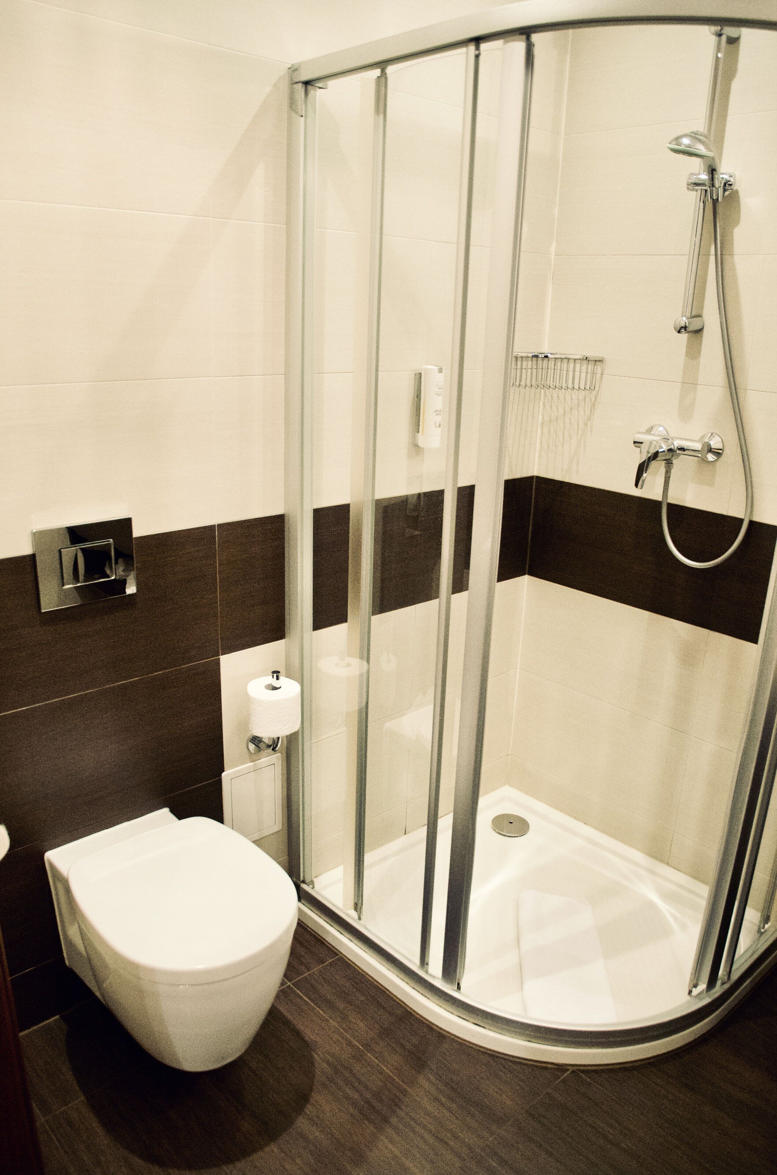 Un baño moderno con ducha de vidrio, inodoro y toallero.