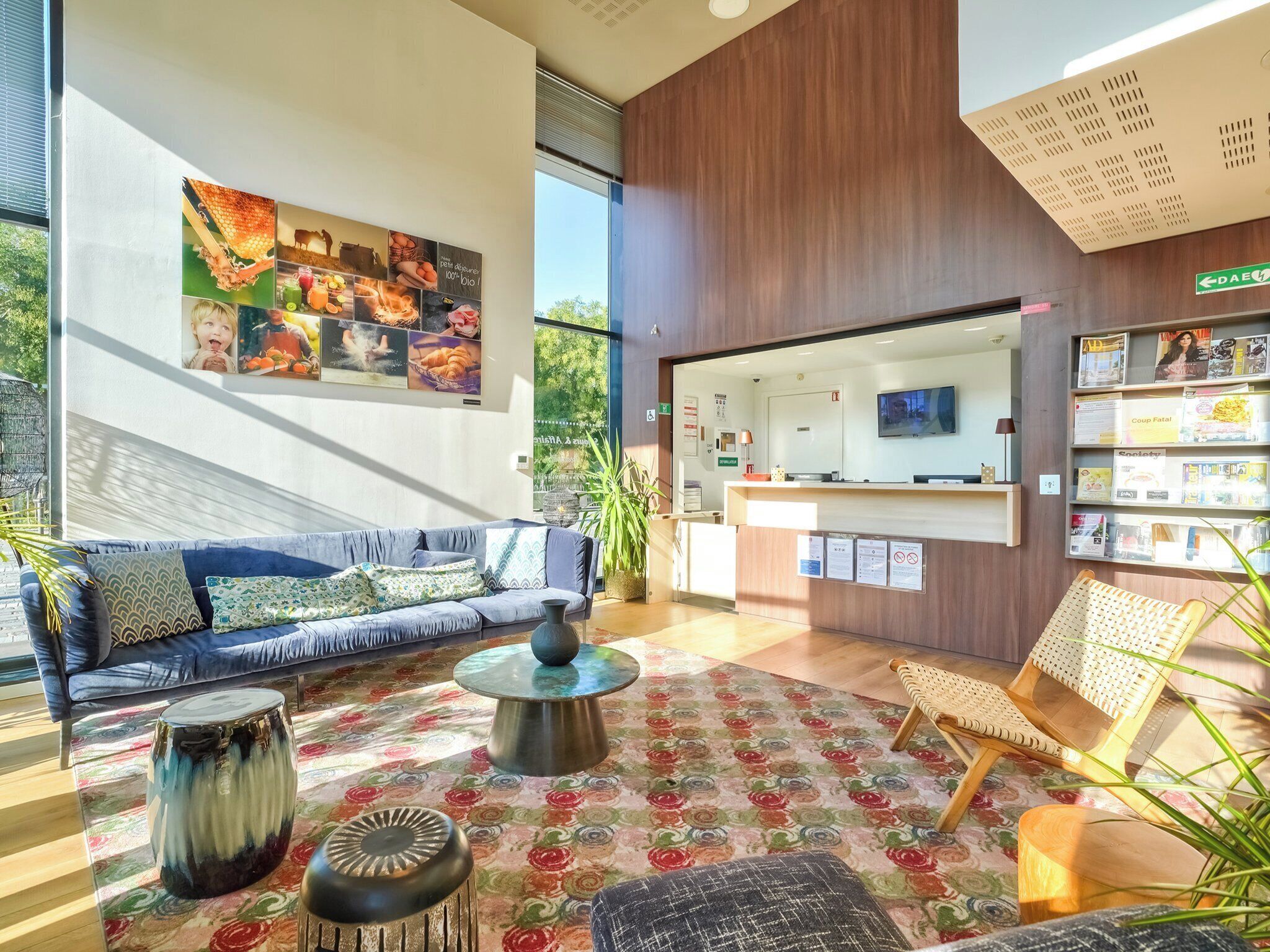 A modern reception area with a sofa, a coffee table, a decorative rug, and a reception desk.