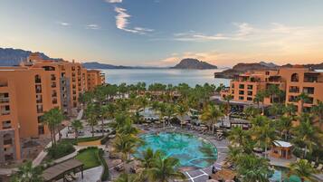 Alberca al aire libre, sombrillas en la alberca y camastros