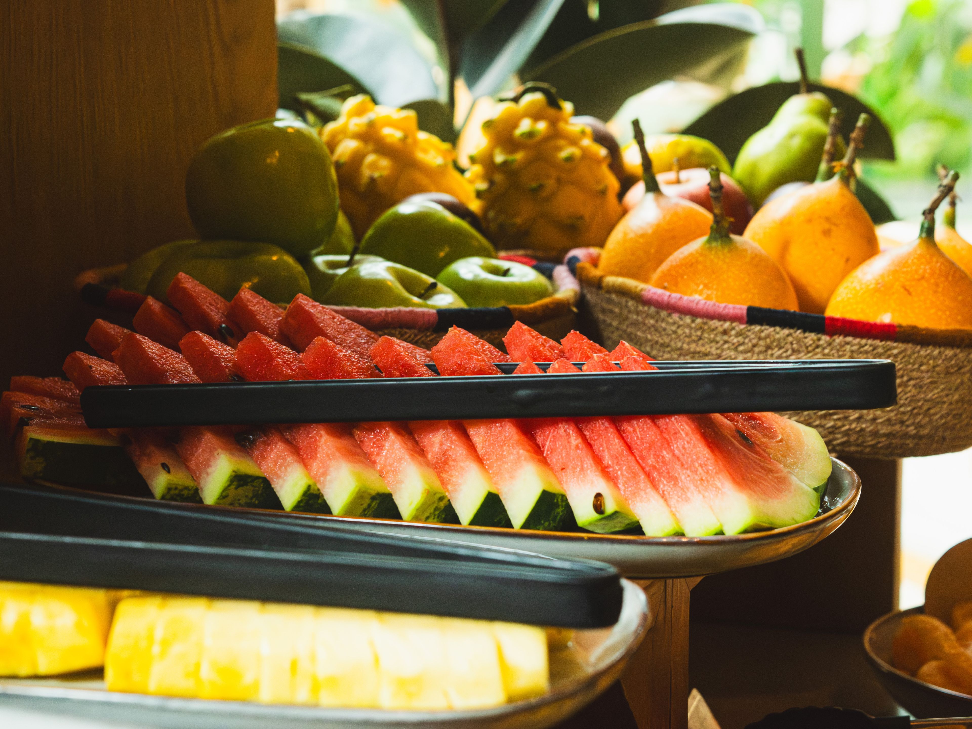 Eine Obstplatte mit Wassermelone, Äpfeln und Orangen.