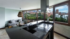 Una cocina moderna con un ventanal grande, un lavamanos integrado y vistas a la ciudad.