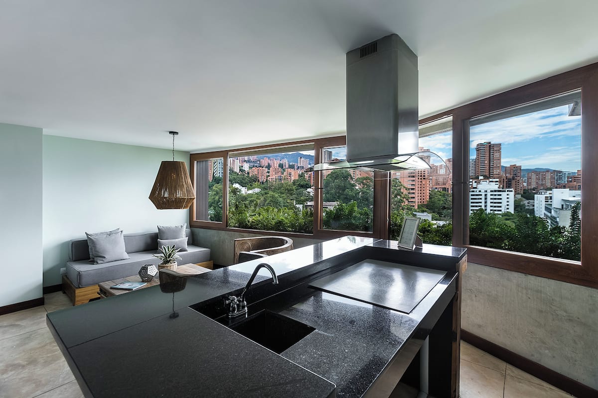 Eine moderne Küche mit großem Fenster, integriertem Spülbecken und Blick auf die Stadt.