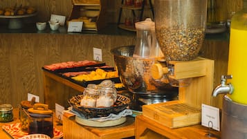 Montaje de bufé con diversas opciones de comida y una máquina de café.