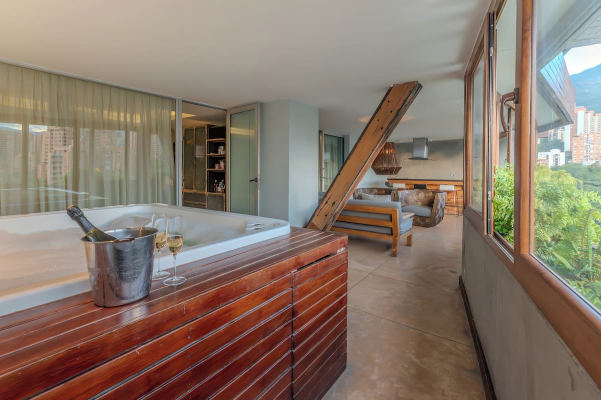 Ein modernes Badezimmer mit einem Holzbadezimmerhocker, einer Badewanne und einer Duschkabine.