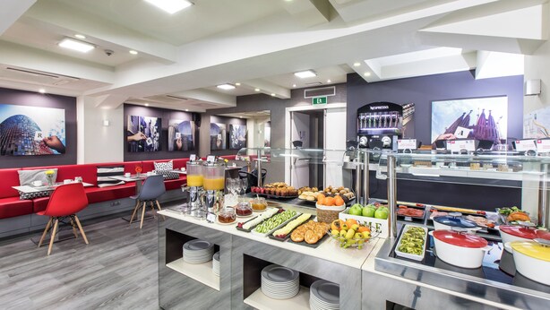 A modern breakfast buffet with a variety of food options, seating areas, and a coffee station.